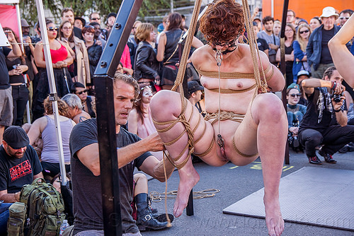 naked woman in suspension bondage - folsom street fair 2015 (san francisco), carnival mask, chain, clamp, clover clamps, fetish, lace mask, masked, nude, rope bondage, suspension bondage, topless, woman